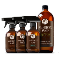 American Maid plant-based cleaning products, including bathroom cleaner, general cleaner, glass cleaner, and prairie wood scented solution, display elegantly against a black background.
