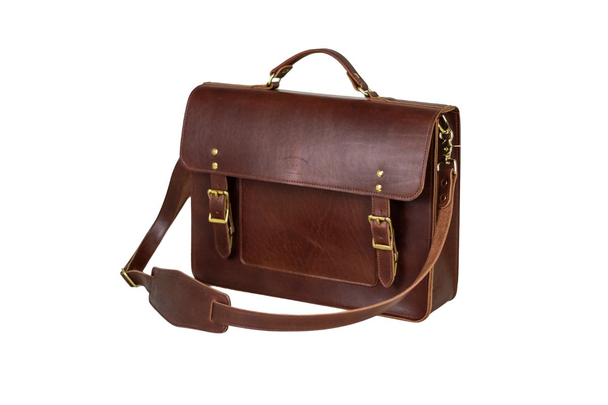 Showcases a stylish brown leather satchel briefcase with buckled pockets and a shoulder strap.
