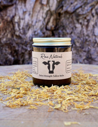 Showcases Rowe Naturals extra strength tallow balm jar surrounded by dried calendula petals, promoting organic skincare.
