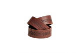Stack of brown leather bracelets displays the phrase "Fiercely Loved" in black lettering.
