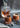 A crystal decanter sits behind two whiskey glasses, each wrapped in personalized leather sleeves, next to chilling stones and ice tongs, showcasing a refined home bar setup.
