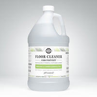 Showcases a gallon jug of Rustic Strength floor cleaner concentrate with bergamot and cypress essential oils.
