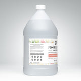A gallon jug showcases Rustic Strength Floor Cleaner Concentrate with lemon, lime, orange, and grapefruit scents for a safe and effective hard surface cleaning solution.
