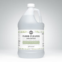 Shows a gallon jug of Rustic Strength floor cleaner concentrate with rosemary, mint, and tea tree essential oils.
