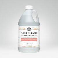 A bottle of Rustic Strength floor cleaner concentrate boasts its plant-based formula with lemon, lime, orange, and grapefruit essential oils.
