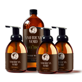American Maid's plant-based foaming hand soap and all-purpose cleaner bottles sit arranged against a black background.
