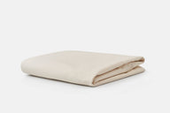 A neatly folded beige cotton canvas fabric rests on a plain white background.