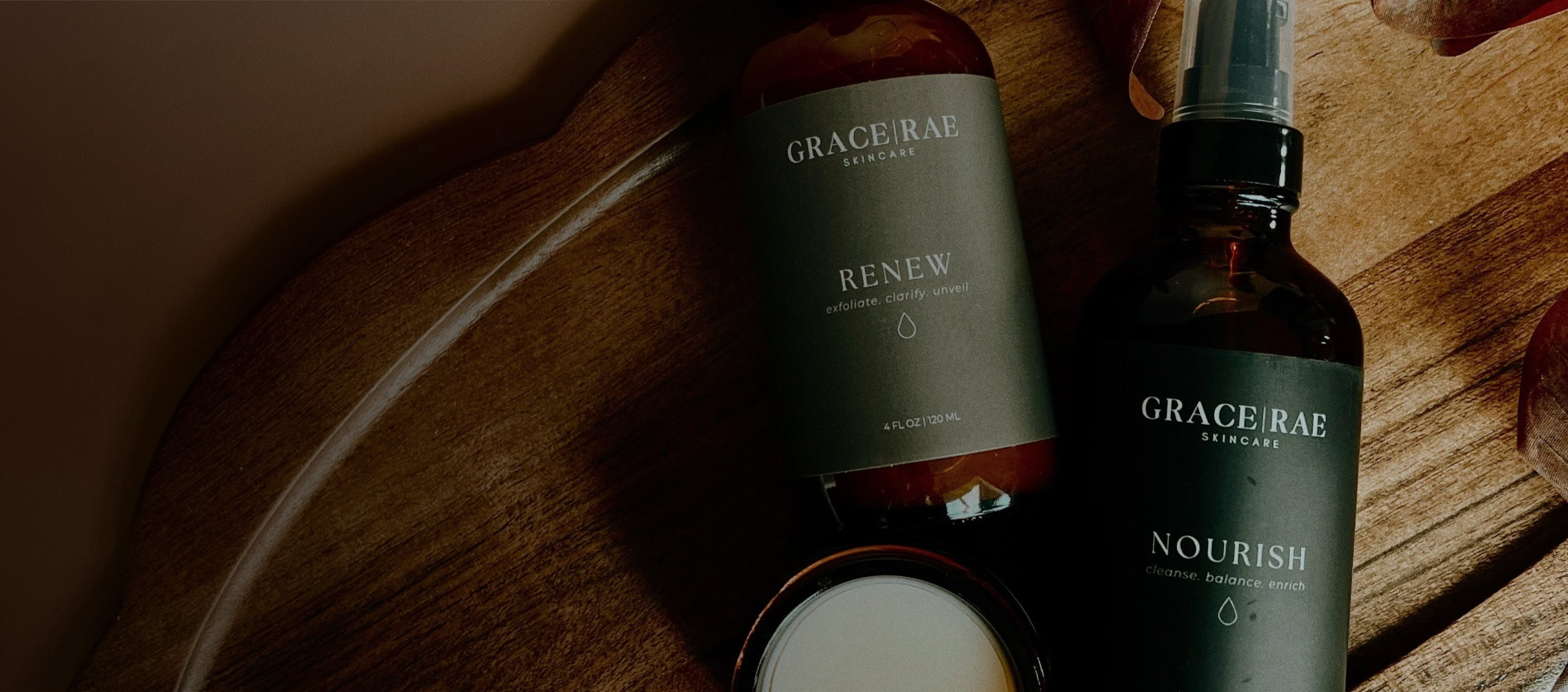 Two bottles of Grace & Rae skincare products on a wooden surface.