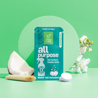 Green Llama's compostable all-purpose cleaner refill featuring lemongrass scent sits among fresh coconut, lemongrass, and white flowers.
