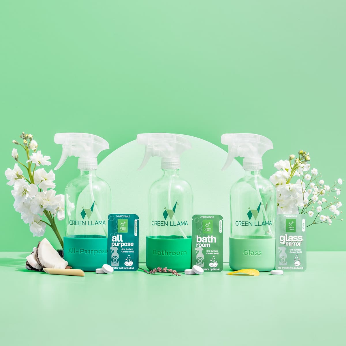 Green Llama showcases its eco-friendly, compostable cleaning products including all-purpose, bathroom, and glass cleaners on a pastel green background with floral accents.
