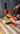Hot sauce bottle being squeezed onto a piece of bread with a blurred background