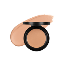 An open compact of beige foundation sits beside a swatch of the same makeup.
