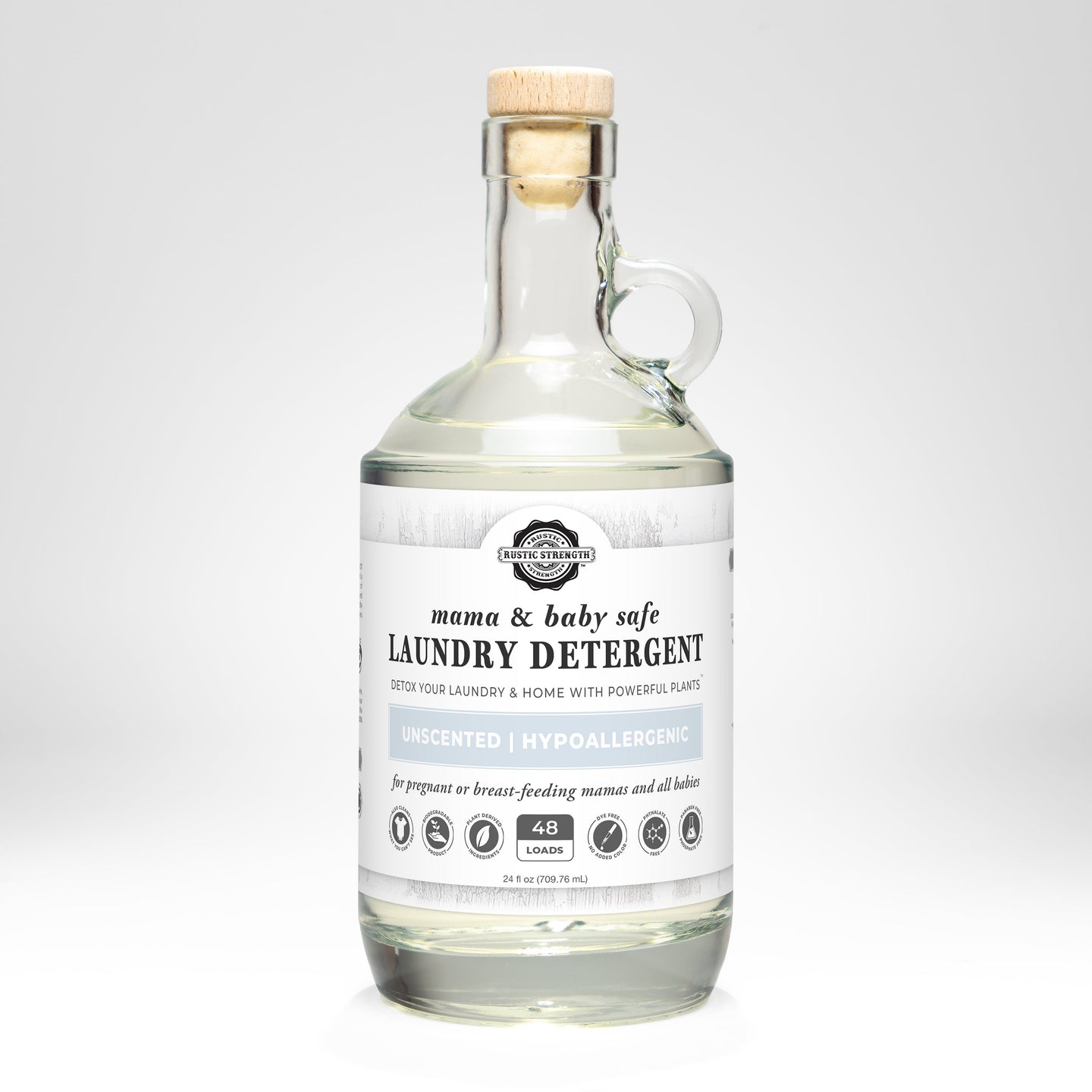 Rustic Strength presents their mama and baby safe, unscented laundry detergent in a clear glass jug with a wooden stopper.
