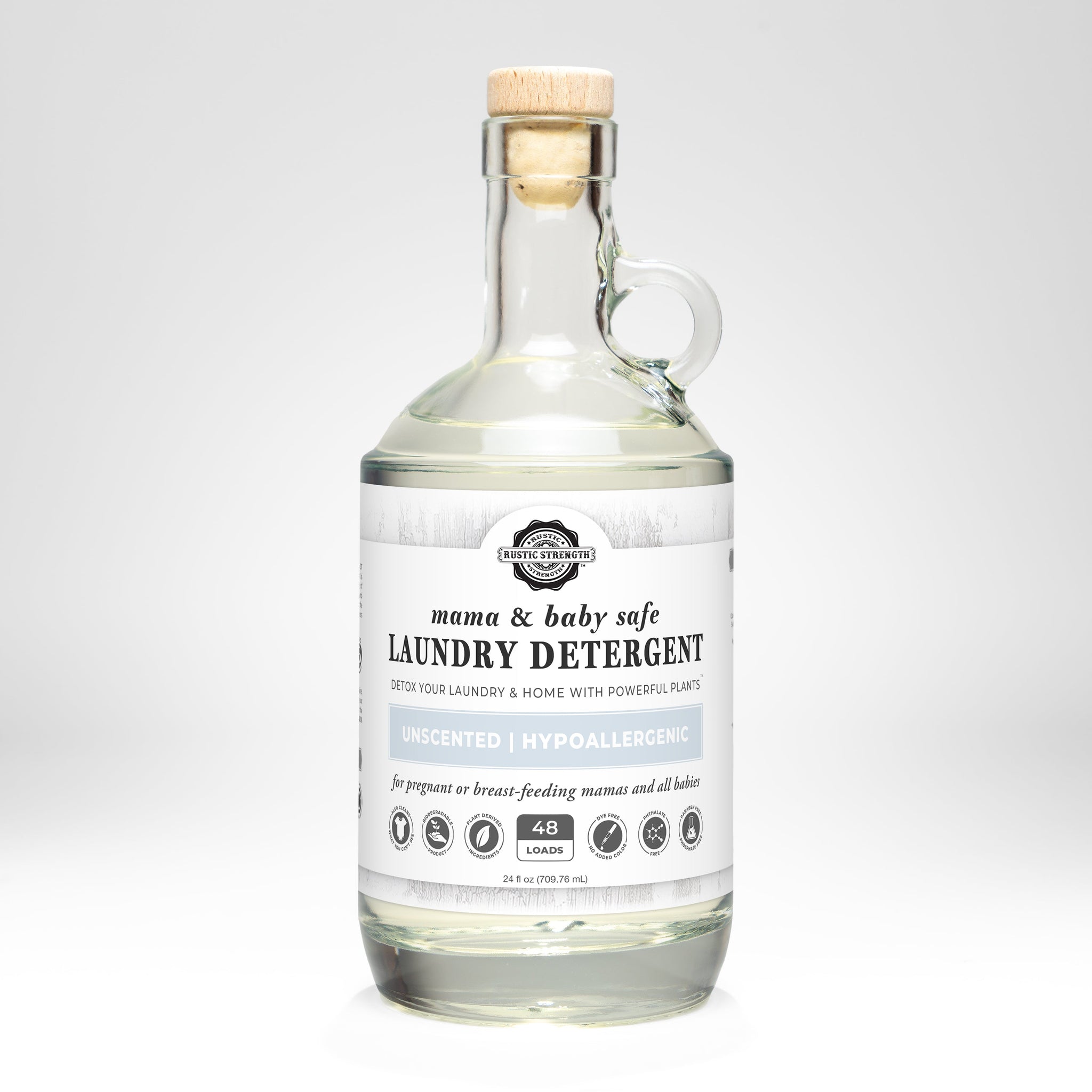 Rustic Strength presents their mama and baby safe, unscented laundry detergent in a clear glass jug with a wooden stopper.
