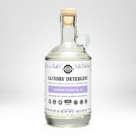 Rustic Strength sells their Lavender Essential Oil laundry detergent in a clear glass bottle with a cork stopper.
