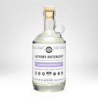 Rustic Strength sells their Lavender Essential Oil laundry detergent in a clear glass bottle with a cork stopper.
