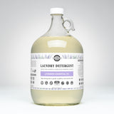 Rustic Strength lavender laundry detergent, featuring natural essential oils, sits in a clear gallon jug promising 256 loads of gentle, effective cleaning.
