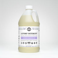 A bottle of Rustic Strength laundry detergent advertises lavender essential oil for deep cleaning and sensitive skin.
