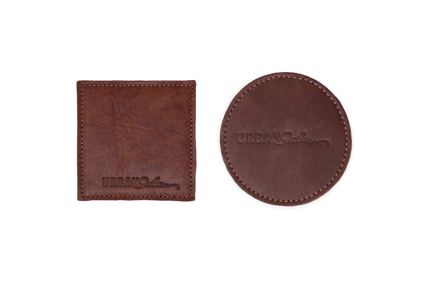 Two brown leather Urban Southern coasters, one square and one round, show stitched edges.
