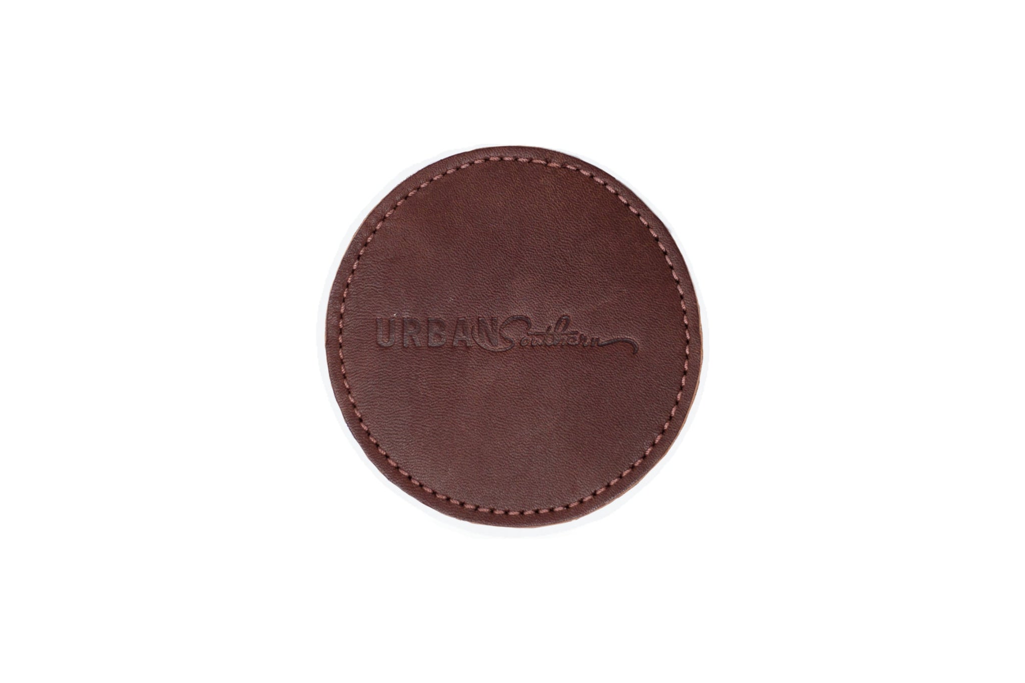 Close-up shows a round, stitched leather coaster with the "Urban Southern" logo embossed.
