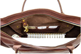 Open brown leather tote bag reveals a spiral notebook, card slots, and attached gold keychain.
