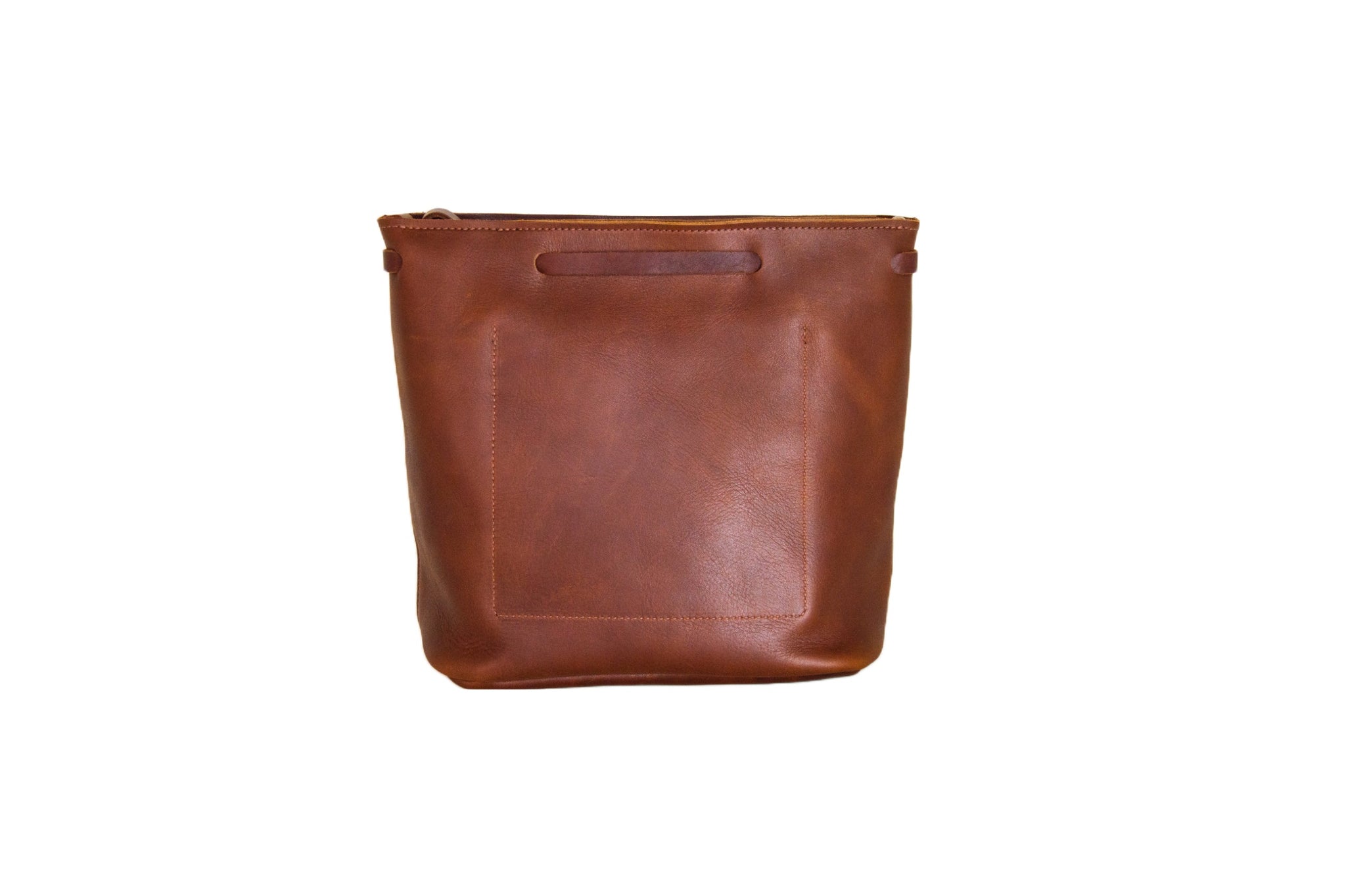 A brown leather bucket bag with a square pocket presents a minimalist and stylish design.
