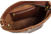 View shows the interior of a brown leather bucket bag with a zippered pocket.