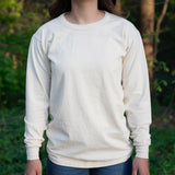 Woman models a sustainable, organic cotton long-sleeve tee shirt outdoors.

