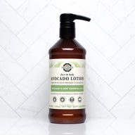 Showcases a bottle of Rustic Strength avocado face and body lotion with rosemary and mint essential oils on a white tile background.