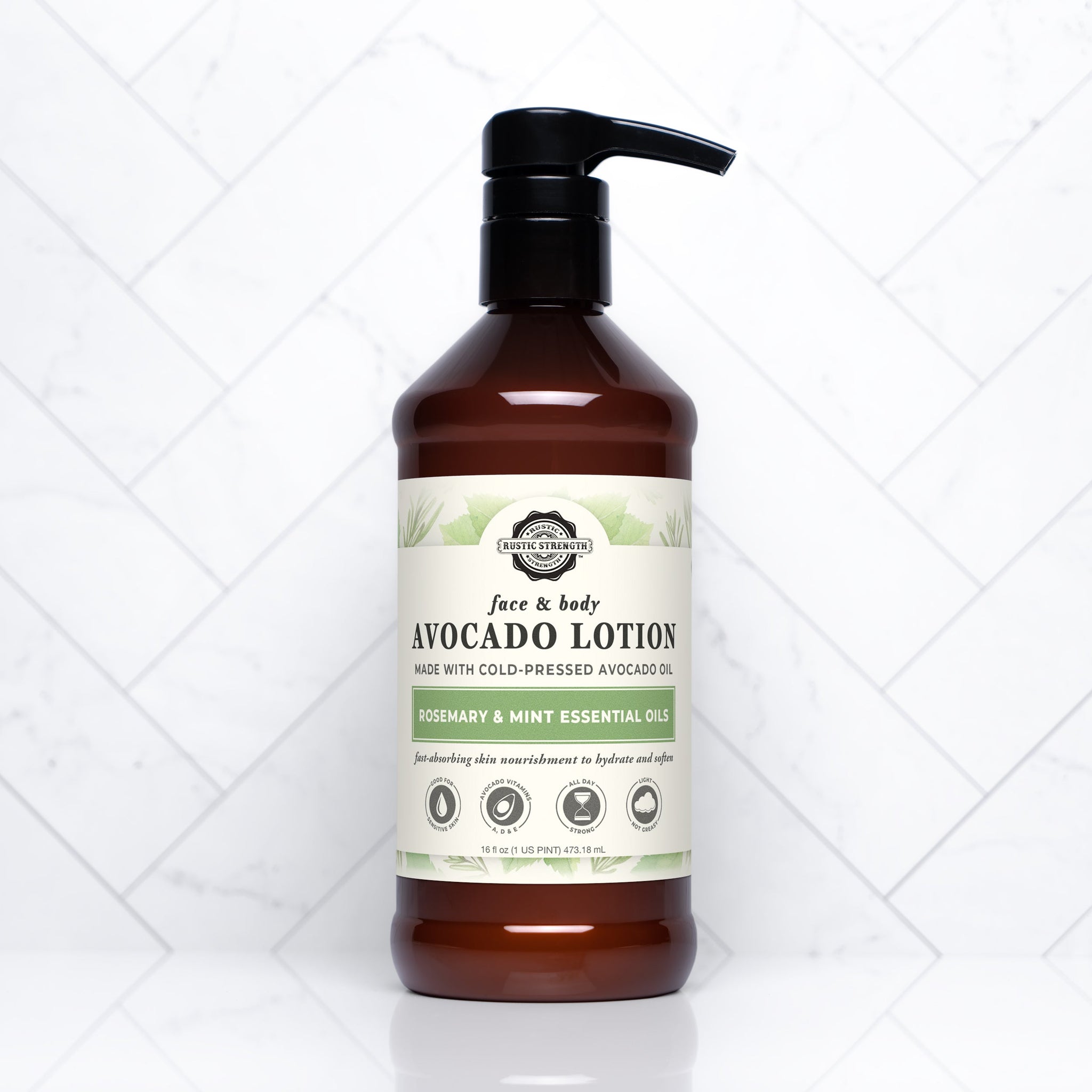 Showcases a bottle of Rustic Strength avocado face and body lotion with rosemary and mint essential oils on a white tile background.