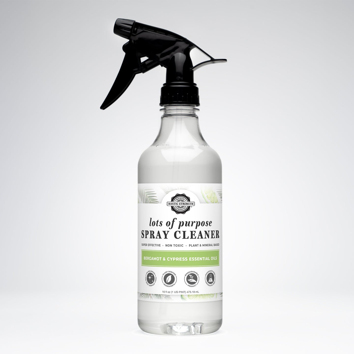 Inspect a clear spray bottle of plant-based, non-toxic Rustic Strength all-purpose cleaner featuring bergamot and cypress essential oils.