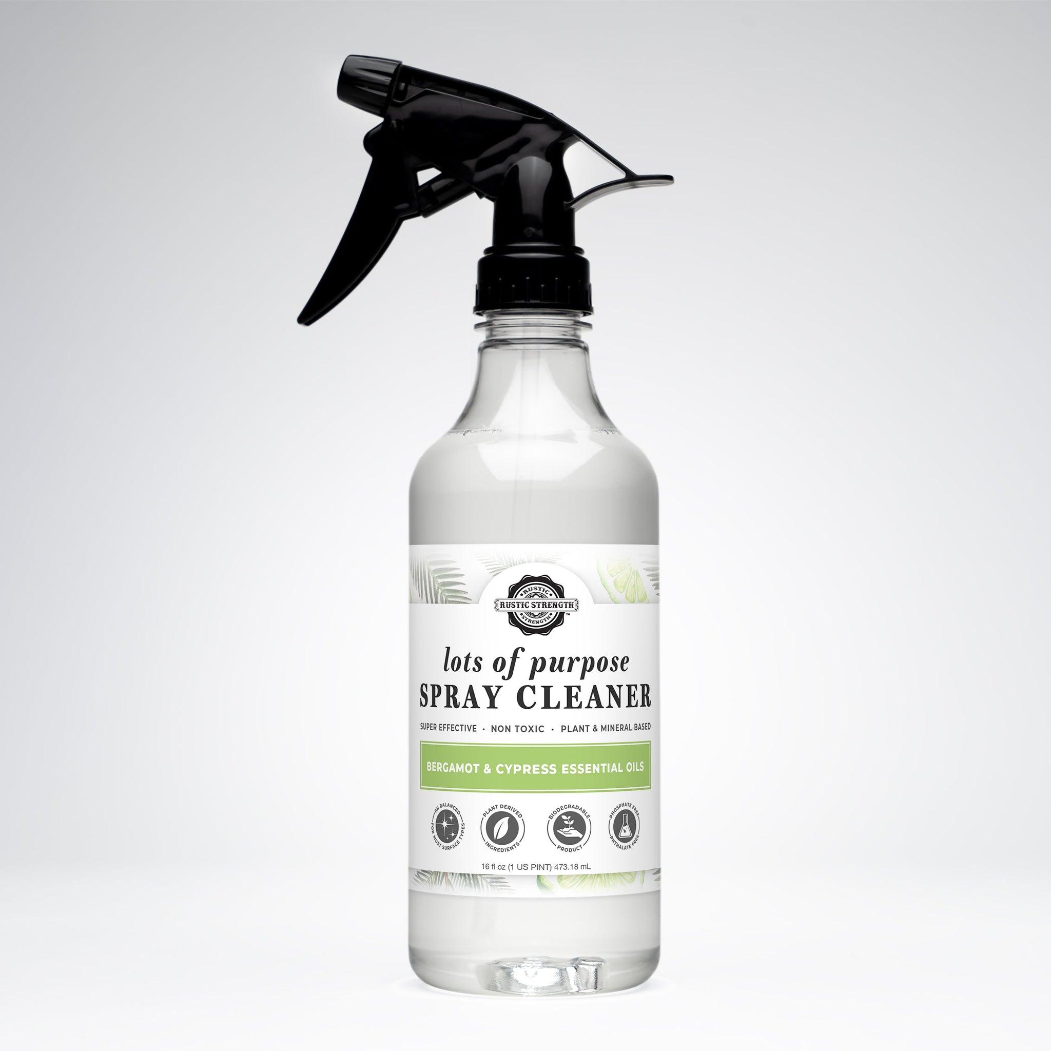 Inspect a clear spray bottle of plant-based, non-toxic Rustic Strength all-purpose cleaner featuring bergamot and cypress essential oils.