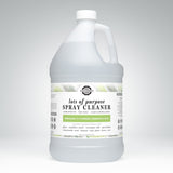 A large jug displays the label for Rustic Strength Lots of Purpose Spray Cleaner, highlighting its bergamot and cypress essential oils.
