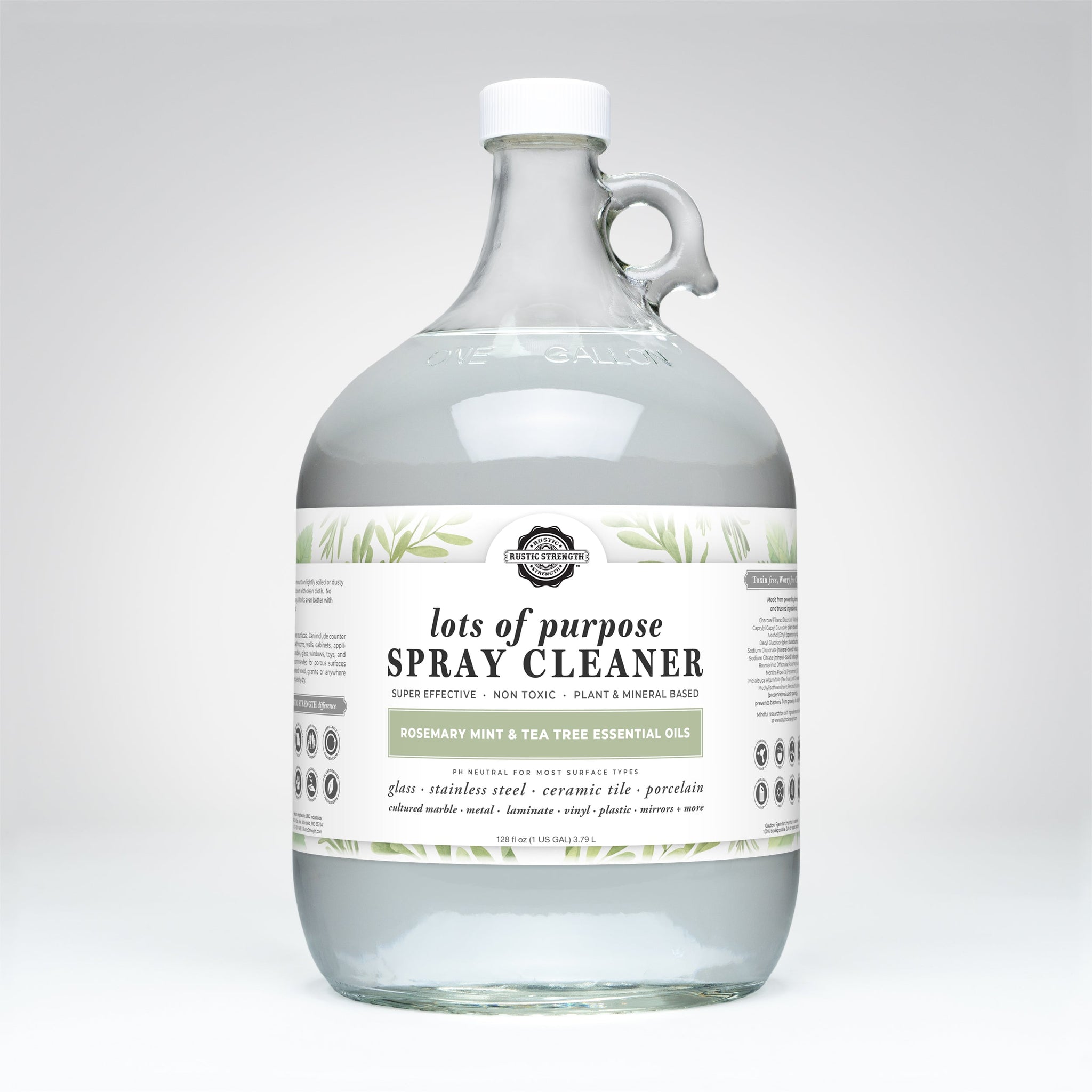 A one-gallon glass jug holds Rustic Strength's Lots of Purpose Spray Cleaner, featuring rosemary mint and tea tree essential oils for a natural cleaning solution.
