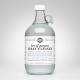 A glass jug displays Rustic Strength lots of purpose, unscented, hypoallergenic spray cleaner suitable for various surfaces.
