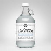 A glass jug displays Rustic Strength lots of purpose, unscented, hypoallergenic spray cleaner suitable for various surfaces.

