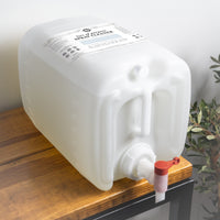 A large container of Rustic Strength multi-purpose spray cleaner sits on a wooden shelf, ready for eco-friendly cleaning.

