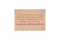 A framed wall decor sign displays a heartwarming quote about love growing best in smaller homes.
