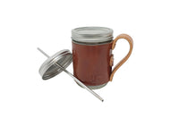A mason jar mug showcases a brown leather sleeve with a handle, a metal lid, and a reusable stainless steel straw.
