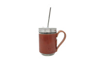 Showcasing a mason jar mug with a brown leather sleeve, stainless steel straw, and a silver lid, perfect for eco-friendly beverage enjoyment.
