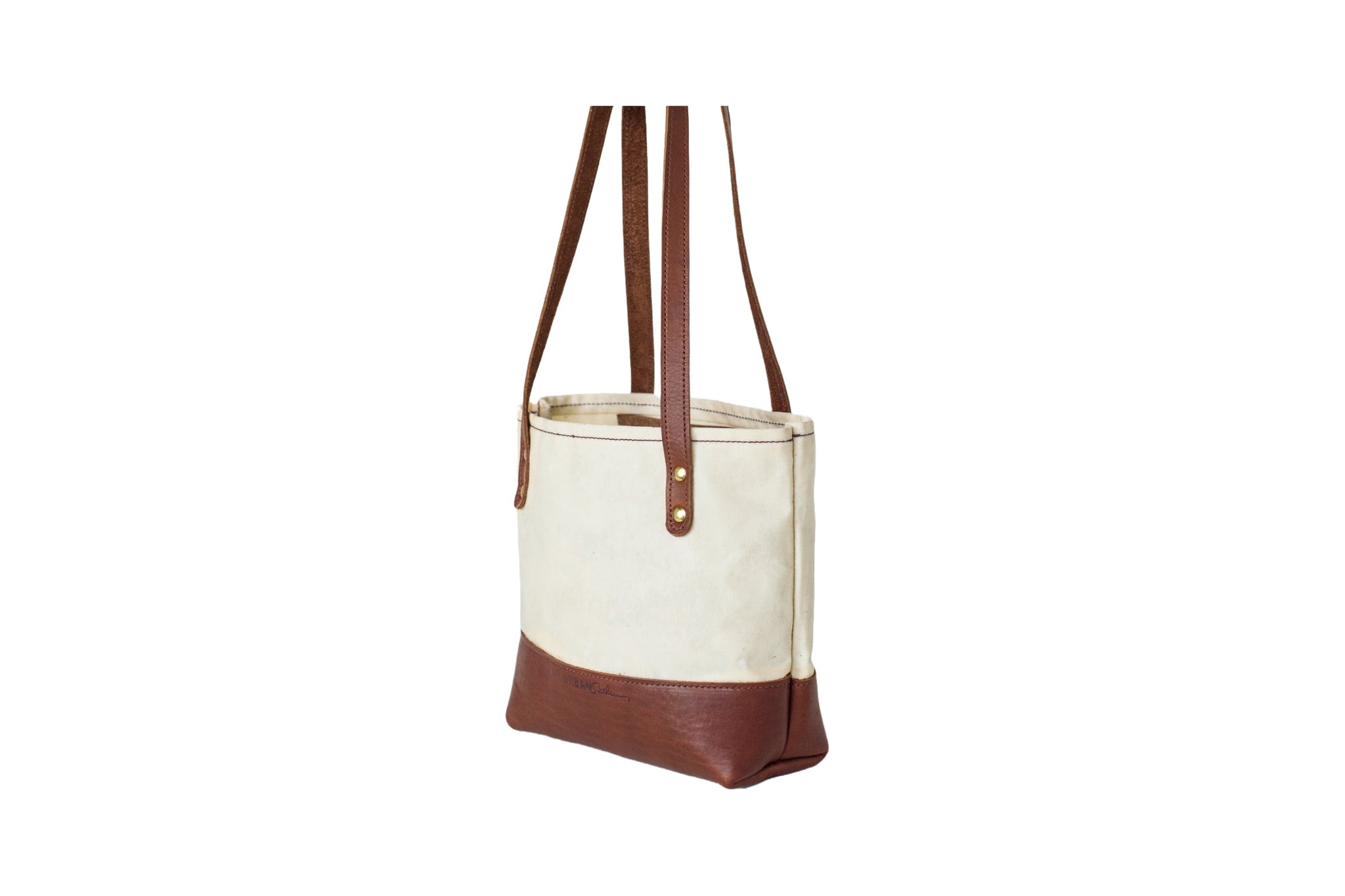 Showcases a stylish canvas tote bag with brown leather accents and sturdy straps.
