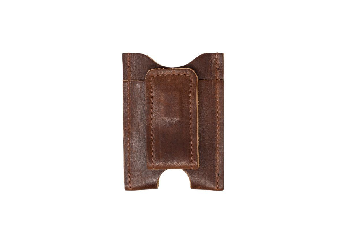 A brown leather minimalist wallet displays its money clip design.
