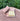 Handcrafted soap rests on a wooden soap dish, displayed on a textured tree stump outdoors.

