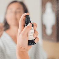 Woman sprays Annmarie Neroli Toning Mist for uplifting skincare.
