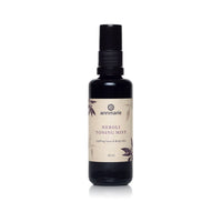 Annmarie Neroli Toning Mist for face and body sits upright in a dark bottle with a spray nozzle.
