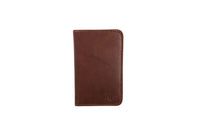 Showcases a brown leather wallet with subtle stitching details and a small embossed logo.
