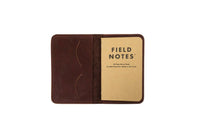 A brown leather Field Notes cover holds a 48-page memo book.
