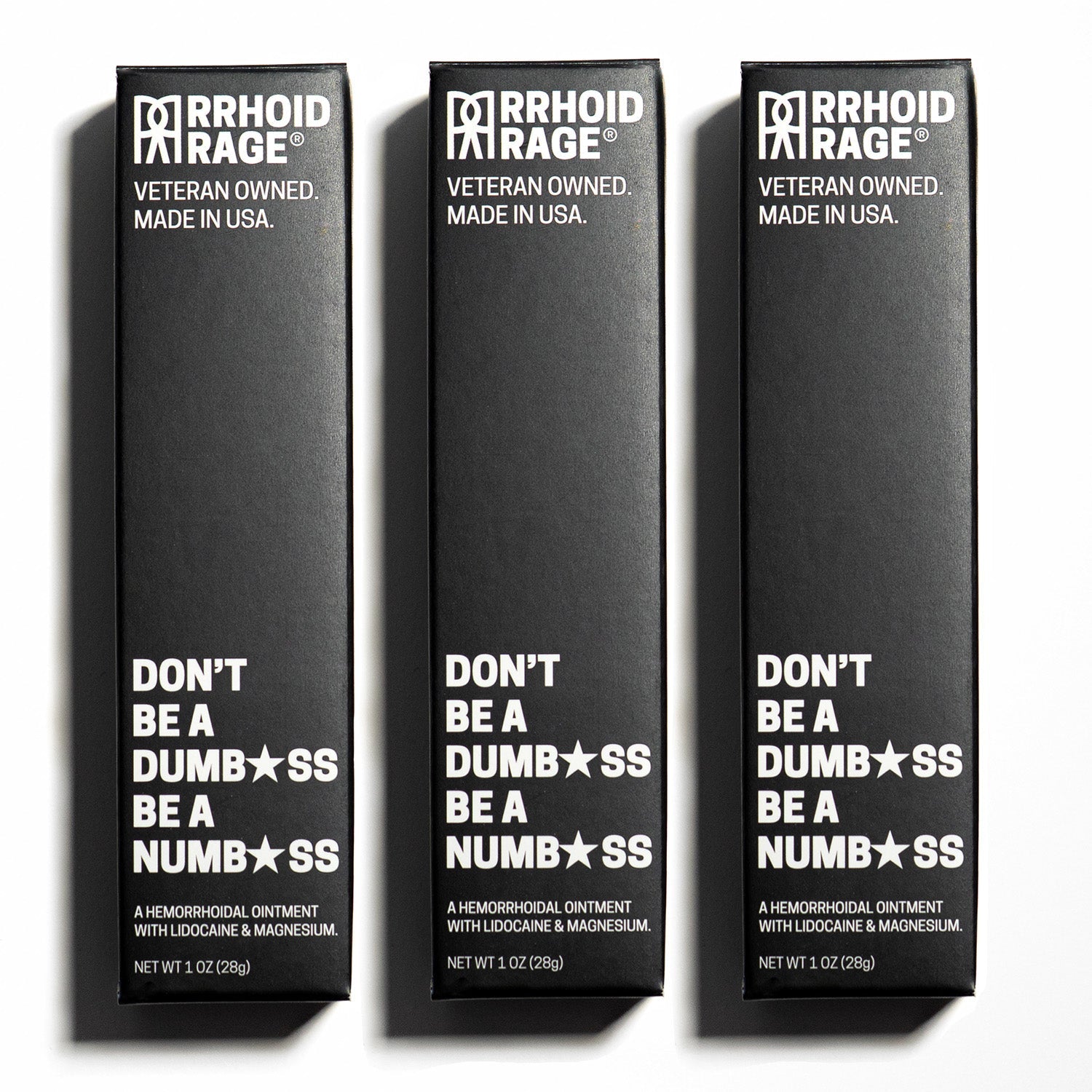 Three boxes of "Rhoid Rage" hemorrhoid ointment stand side-by-side, advertising its numbing and pain-relieving formula made in the USA.
