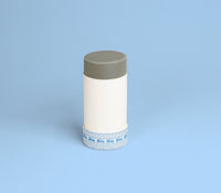 A cylindrical box with a grey lid and a blue vintage van pattern sits on a light blue background.
