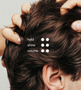 Hands style dark brown men's hair while showing options for hold, shine, and volume.
